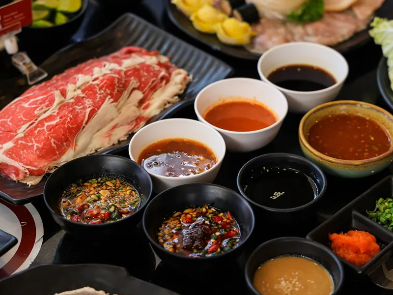 Premium beef slices with a variety of colorful hot pot dipping sauces at Beijing Hot Pot Restaurant, a Hot Pot Restaurant in Portland