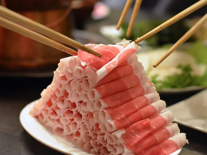 Premium sliced lamb rolls arranged in a mountain shape, ready for hot pot at Beijing Hot Pot Restaurant, a Hot Pot Restaurant in Portland